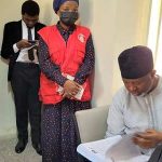 SIRIKA HADI FLIPPING THRU DOCUMENT IN COURT
